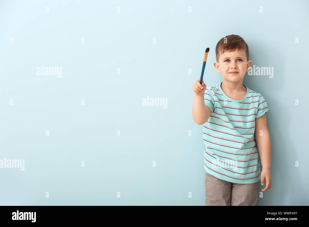 Cute little boy with brush on color background Stock Photo - Alamy
