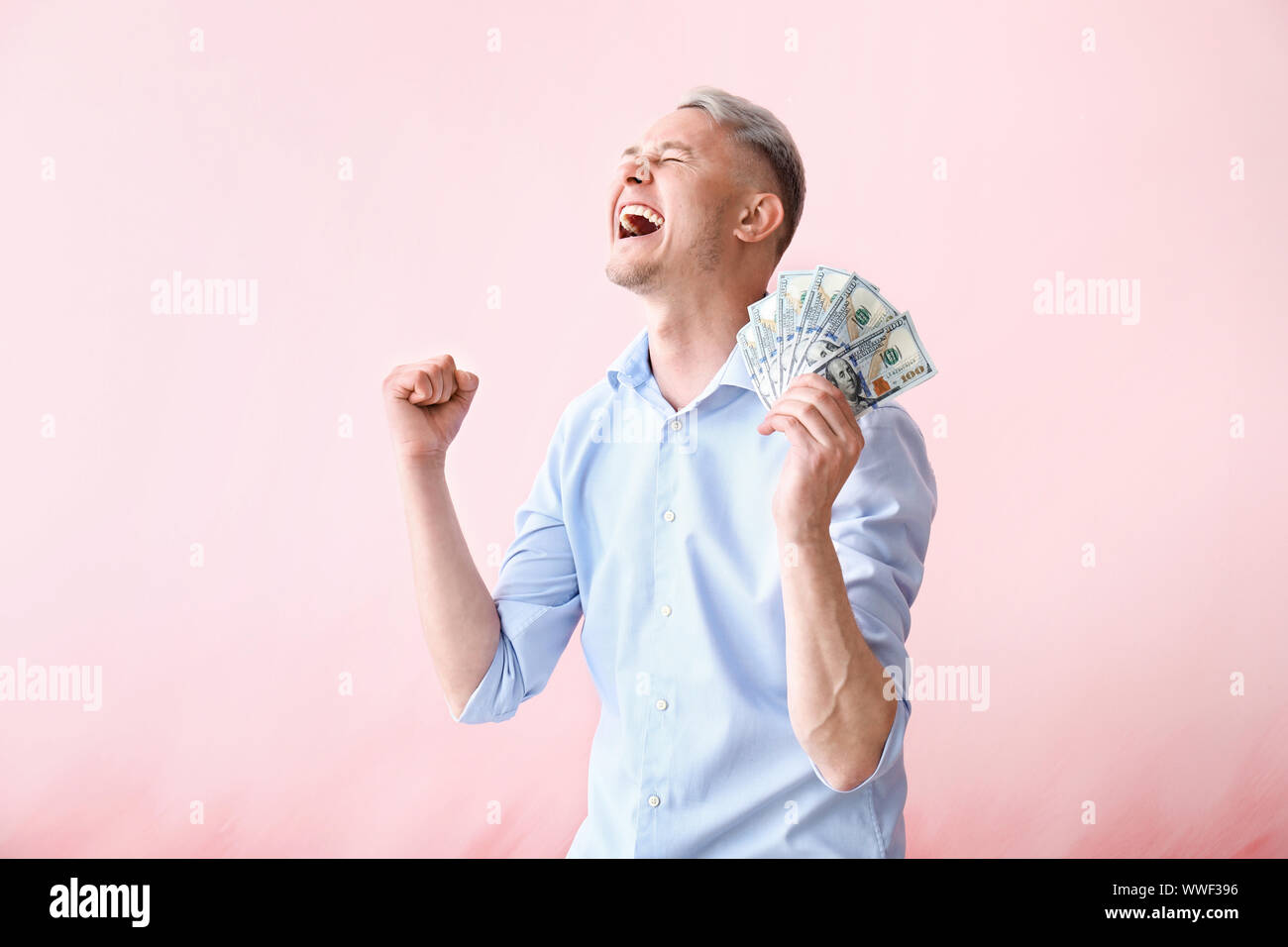 Happy young man with dollar banknotes on color background Stock Photo ...