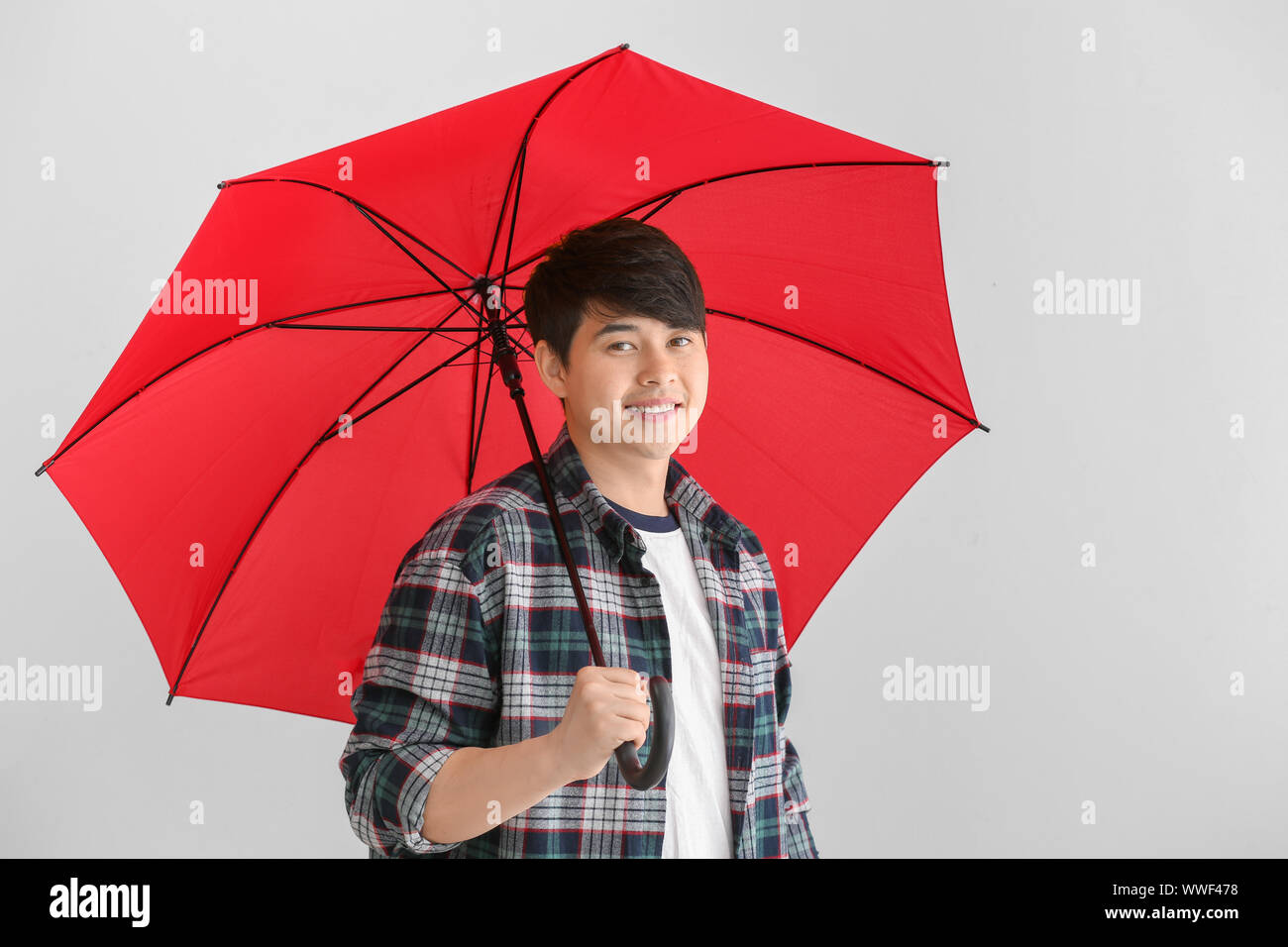 Handsome Asian man with umbrella on white background Stock Photo - Alamy