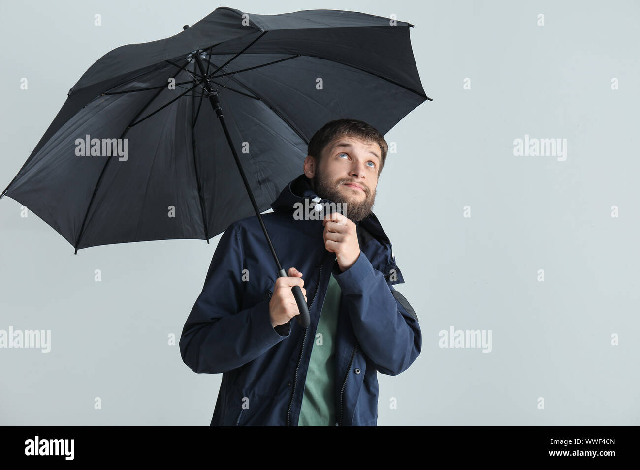 Handsome man with umbrella on white background Stock Photo - Alamy