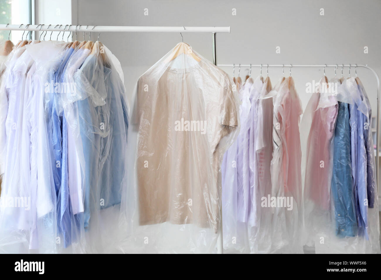 Racks with clothes in modern drycleaner's Stock Photo Alamy