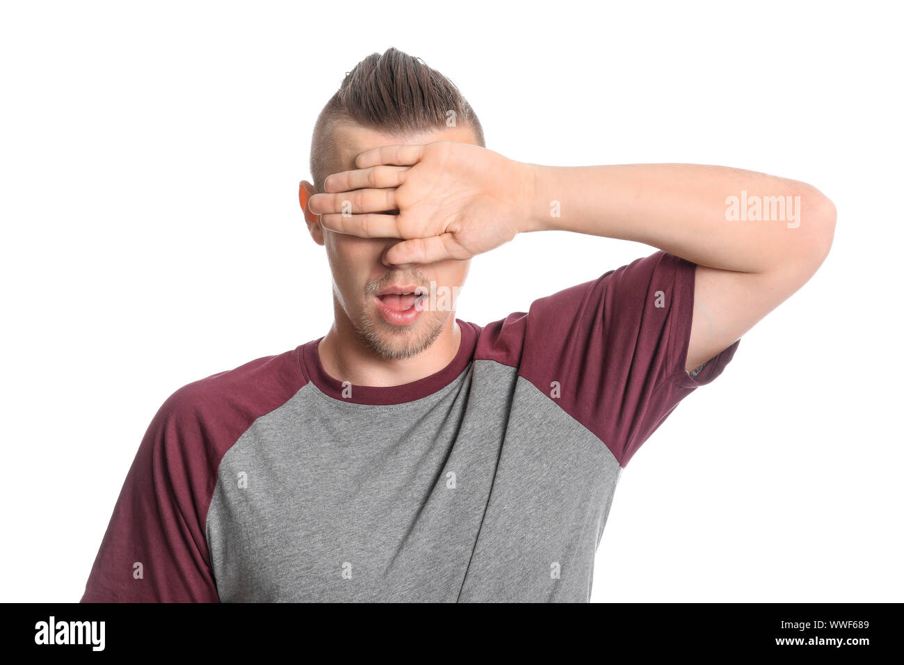 Young man covering his eyes on white background Stock Photo Alamy