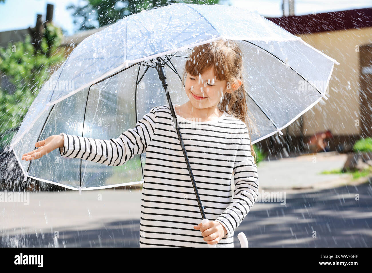 Cute little girl with umbrella outdoors on rainy day Stock Photo - Alamy