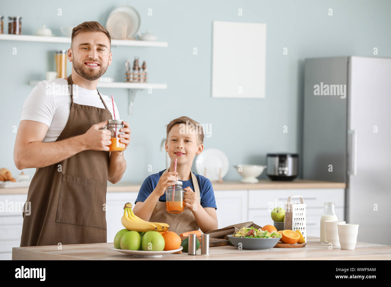 Portrait of happy father and son cooking in kitchen Stock Photo - Alamy