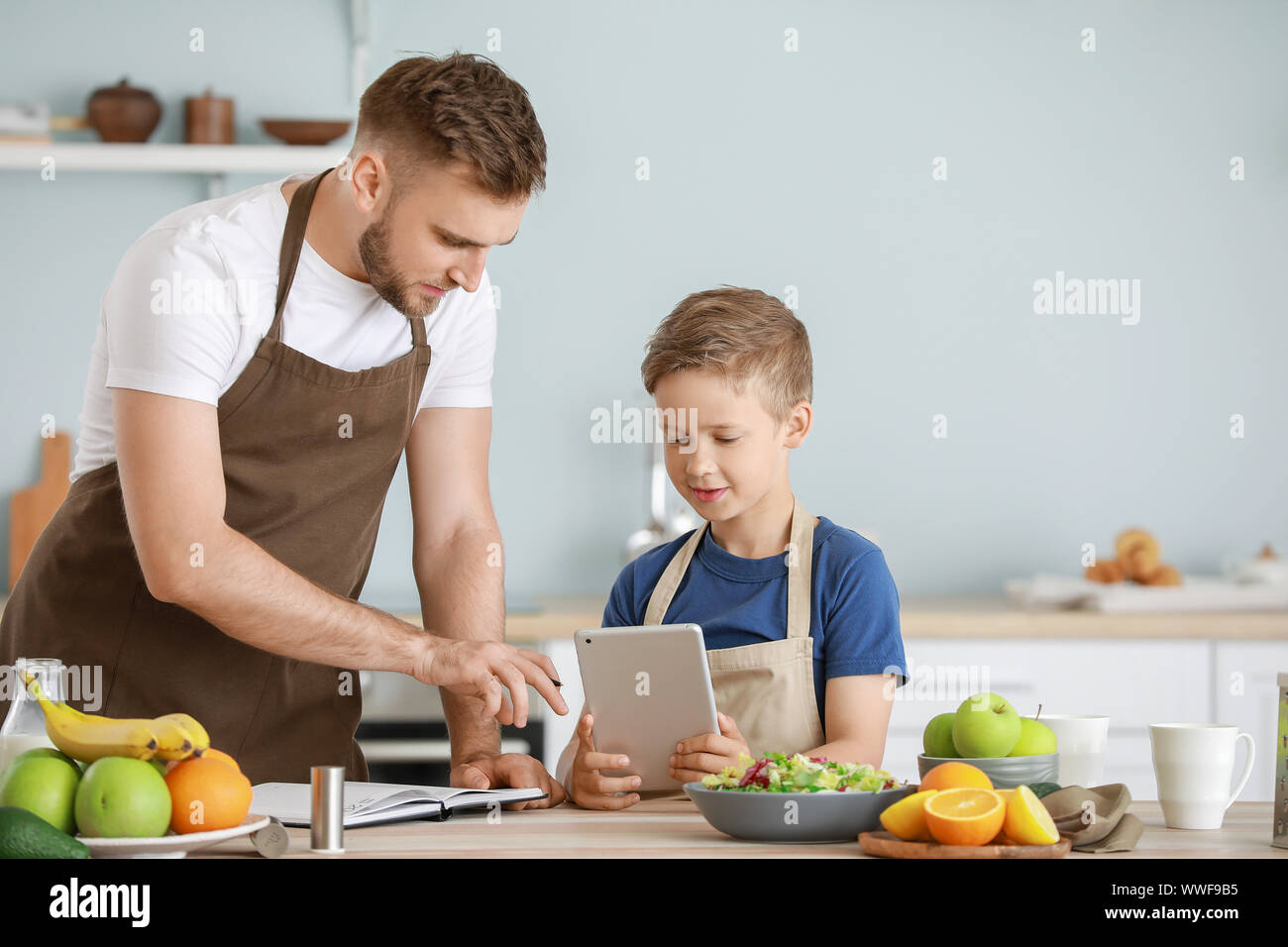 Portrait of happy father and son cooking in kitchen Stock Photo - Alamy