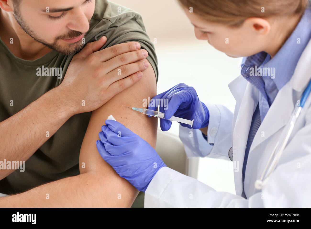 Doctor vaccinating young man hi-res stock photography and images - Alamy