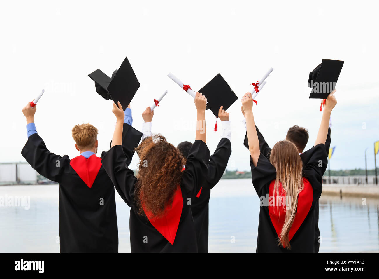 Happy students in bachelor robes outdoors on graduation day Stock Photo ...