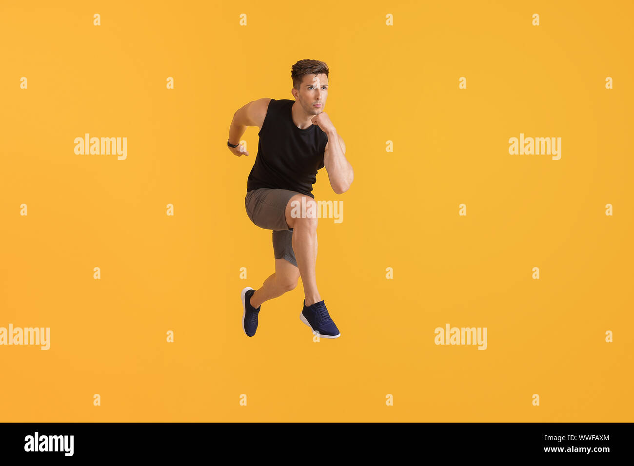 Running young man on color background Stock Photo - Alamy