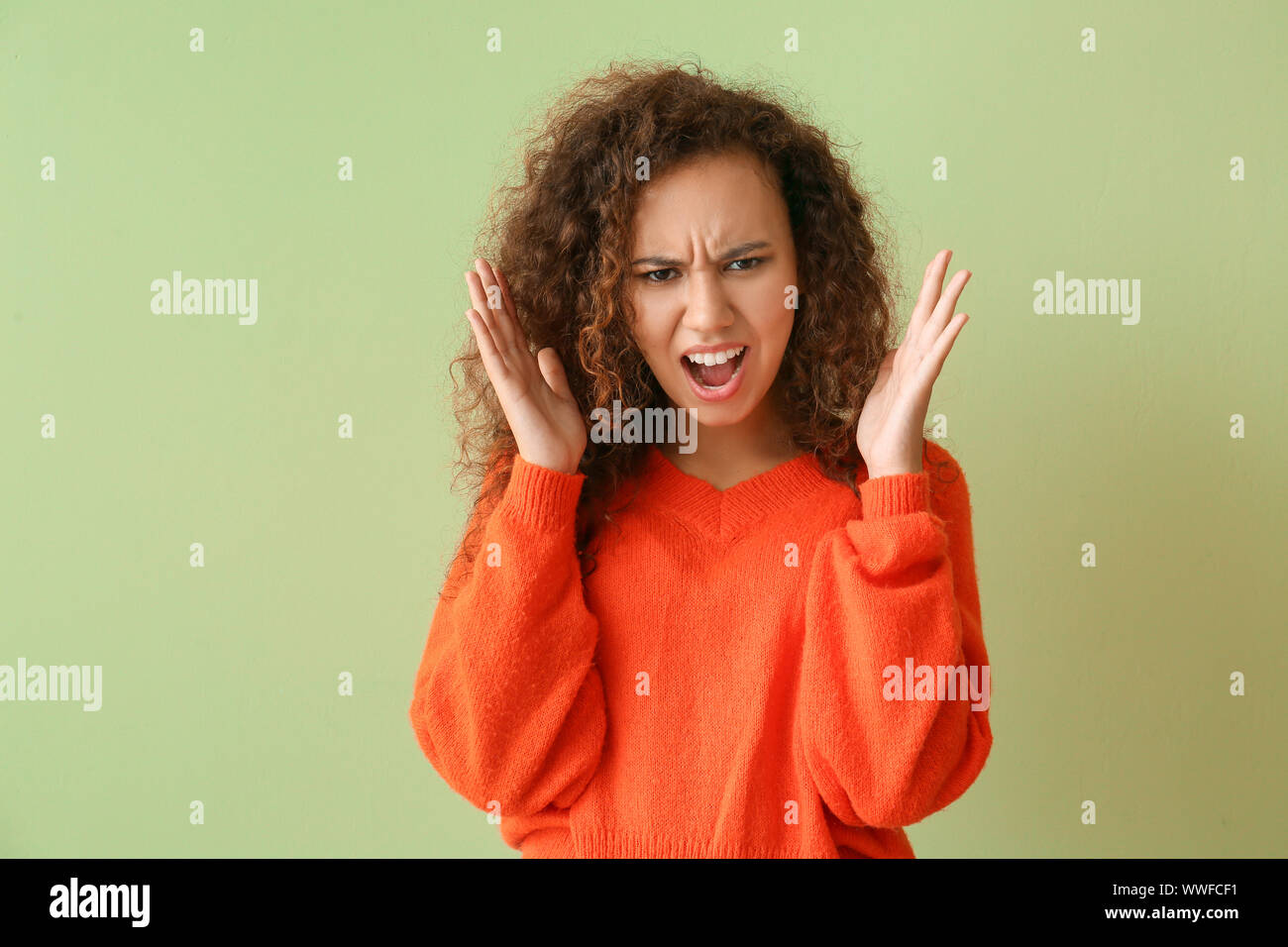 Angry African-American woman on color background Stock Photo - Alamy
