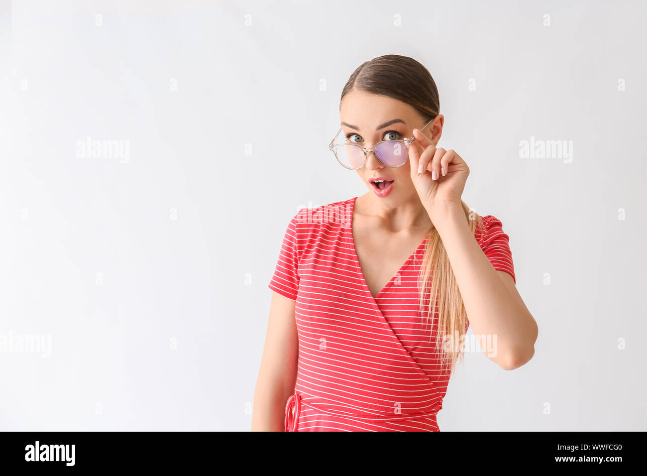 Surprised young woman on white background Stock Photo - Alamy