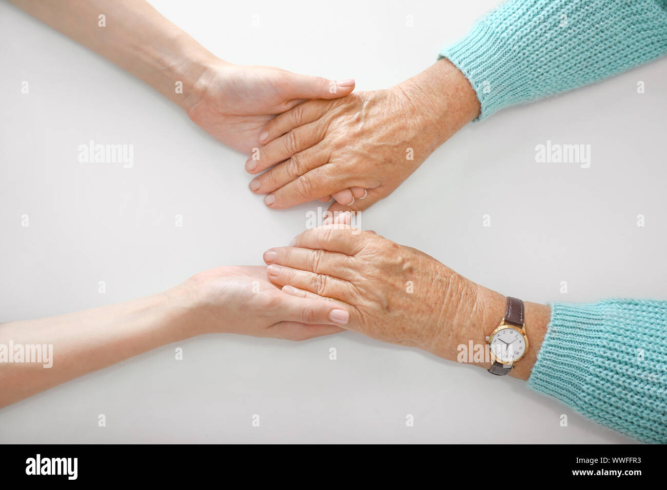 Hands of young and elderly woman on white background. Concept of ...