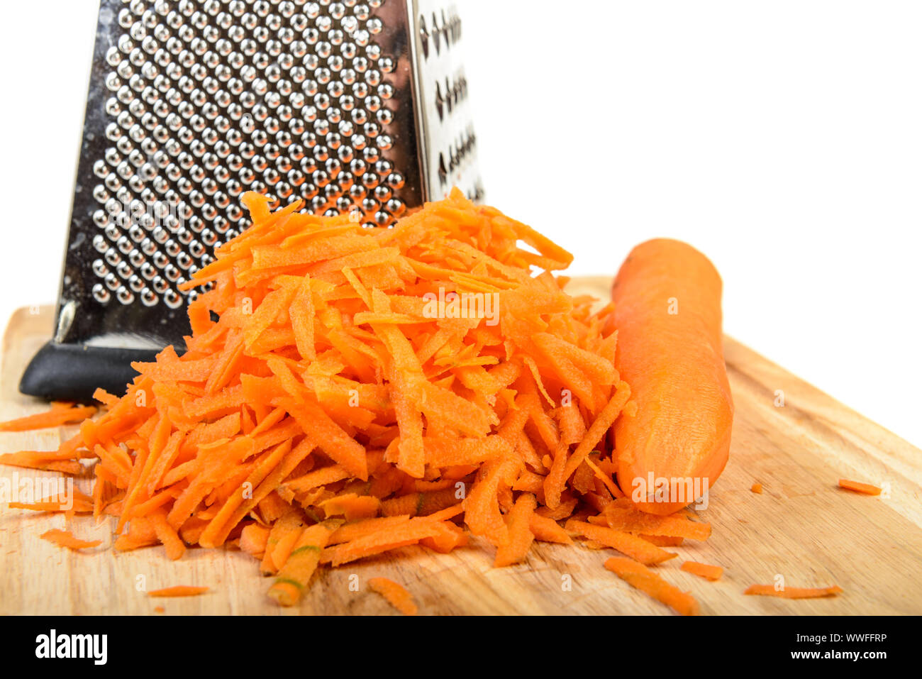 https://c8.alamy.com/comp/WWFFRP/carrots-grated-and-whole-small-grater-on-wooden-board-isolated-over-white-WWFFRP.jpg