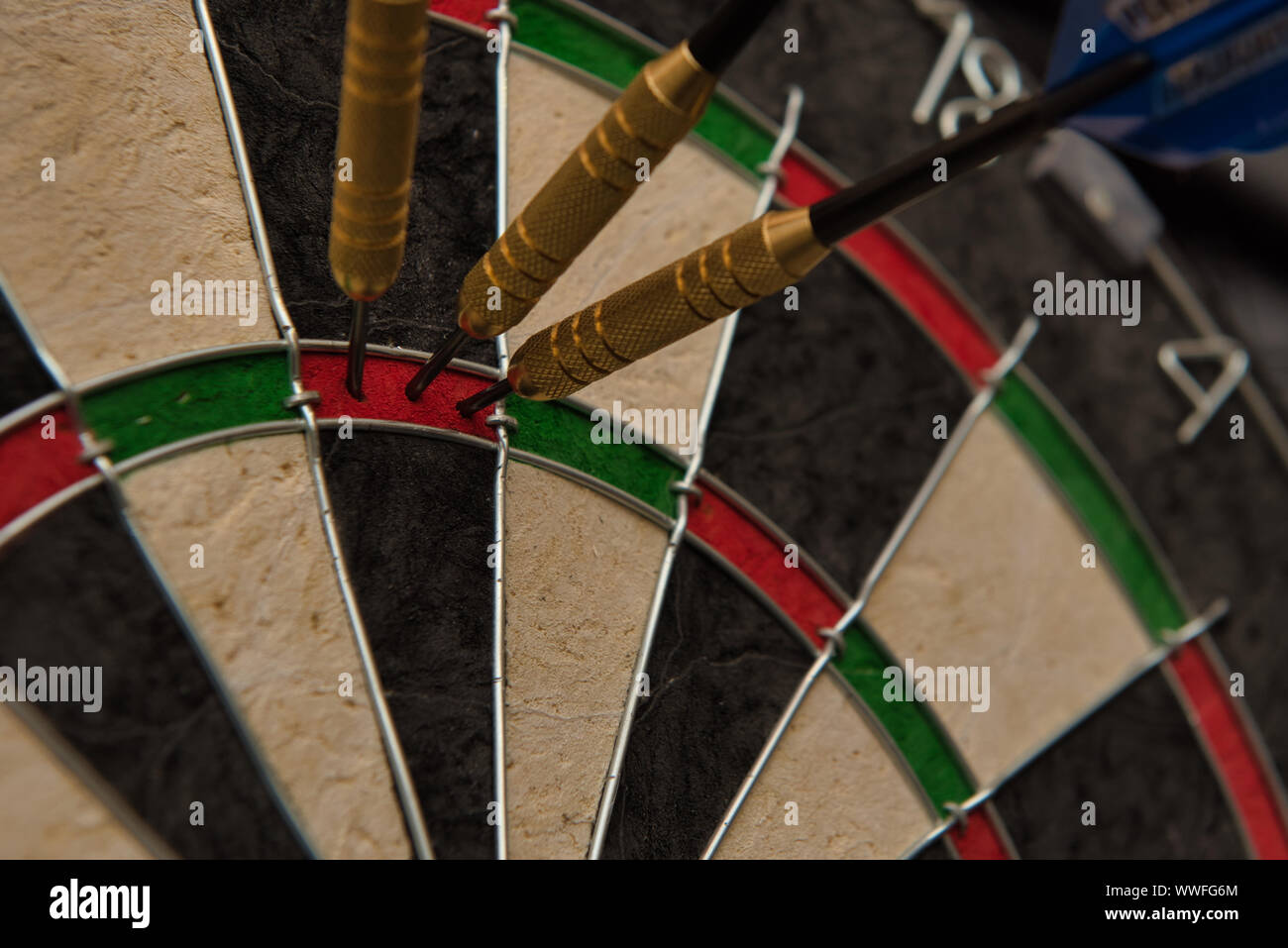 Three darts accurately hit the same area of a dart board Stock Photo