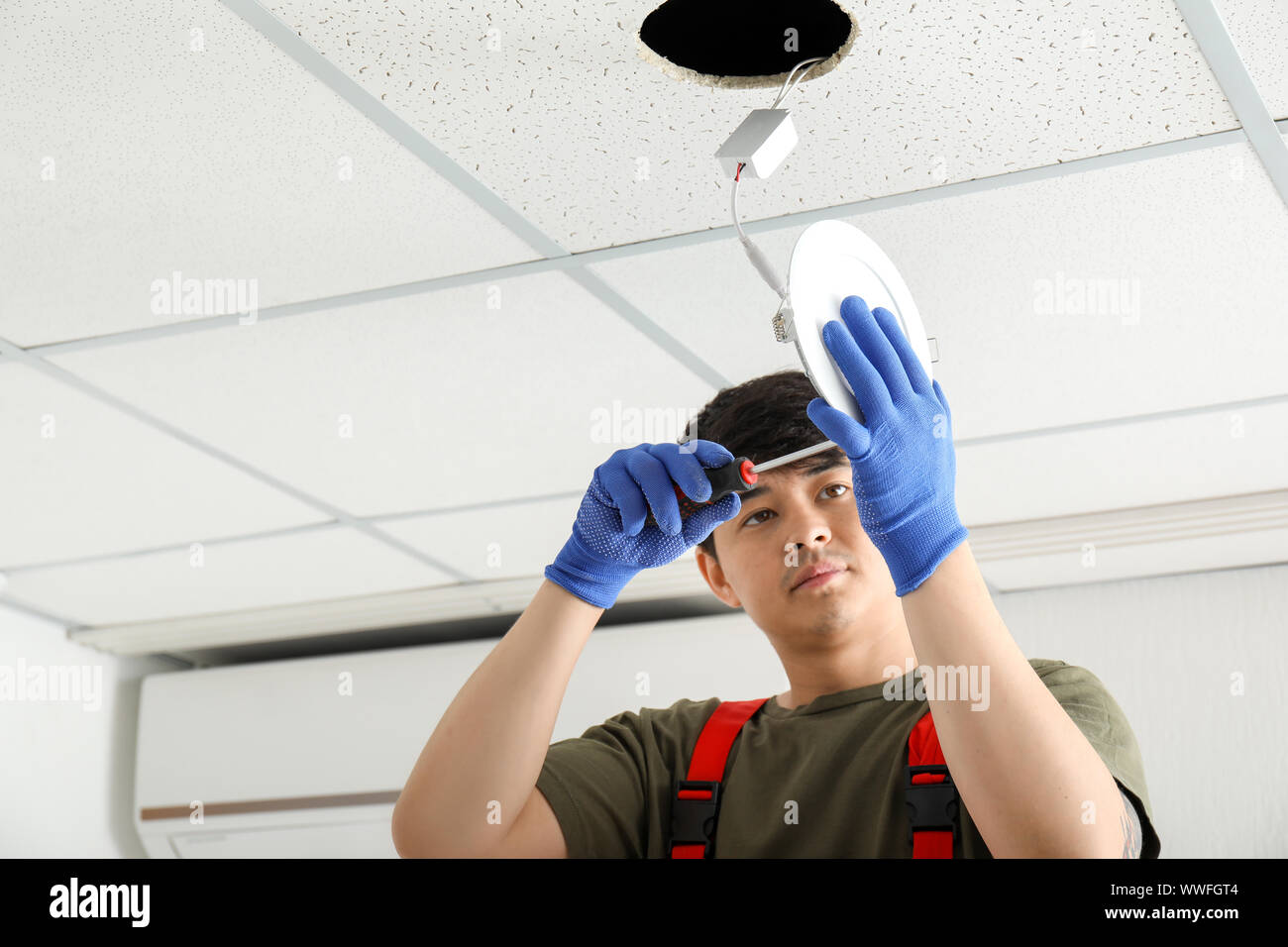 Electrician installing lamp on ceiling Stock Photo - Alamy