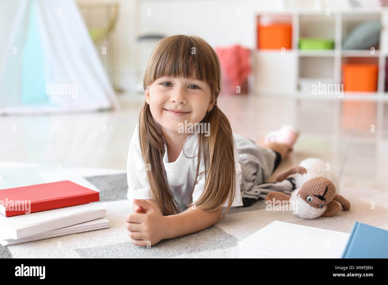 Cute little girl with books at home Stock Photo - Alamy