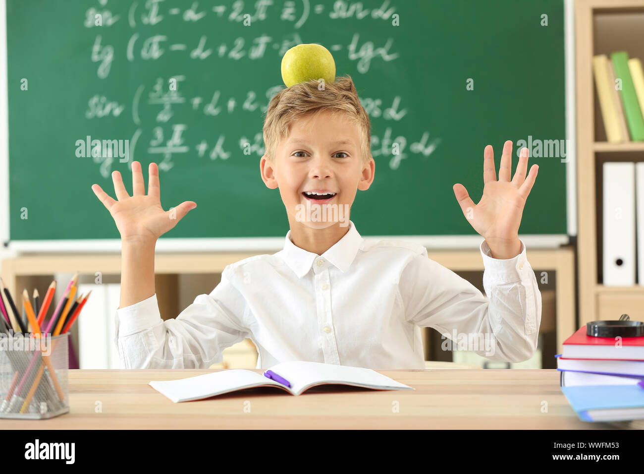 Little boy with apple sitting at desk in classroom Stock Photo - Alamy