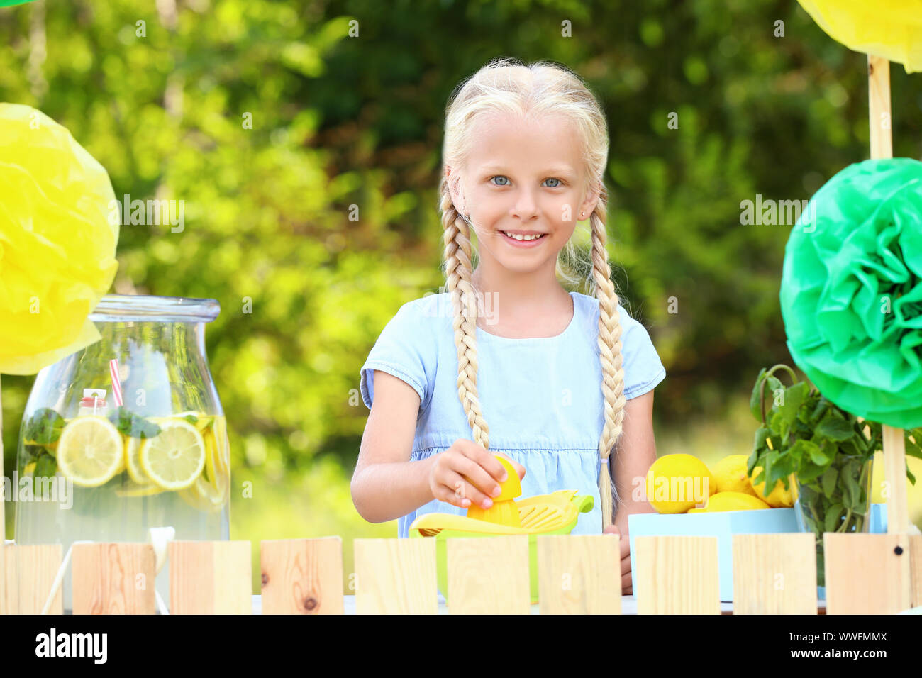 Cute little girl selling lemonade in park Stock Photo