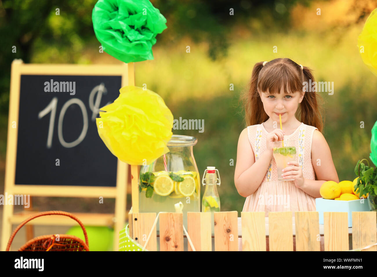 Cute little girl selling lemonade in park Stock Photo