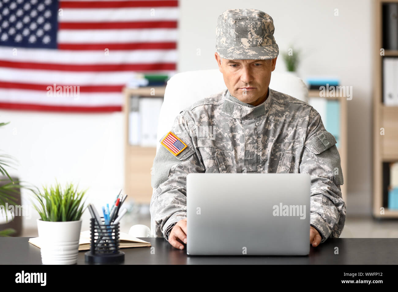 Mature male soldier working with laptop in headquarters building Stock ...