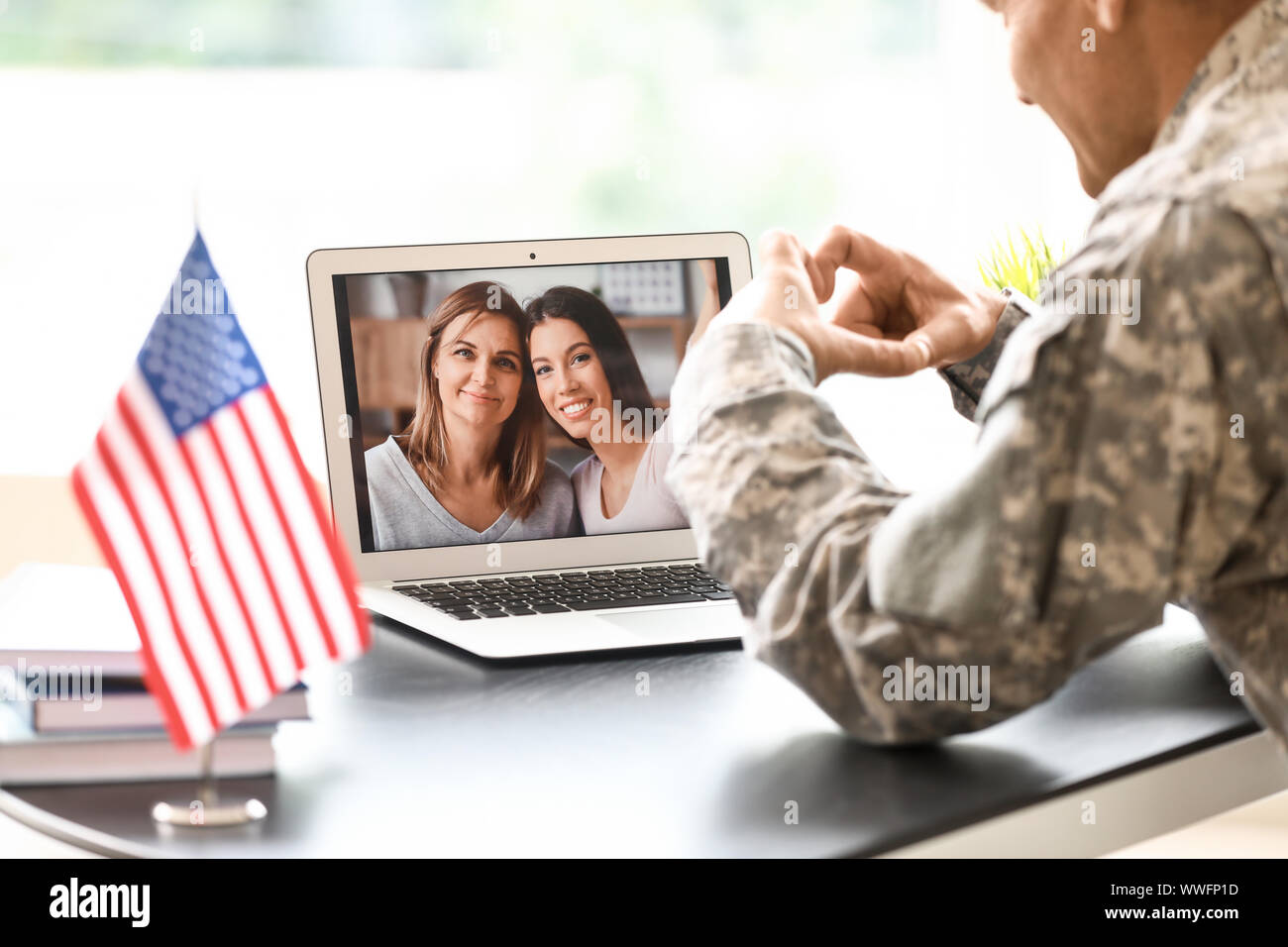 Mature male soldier using laptop in headquarters building for ...