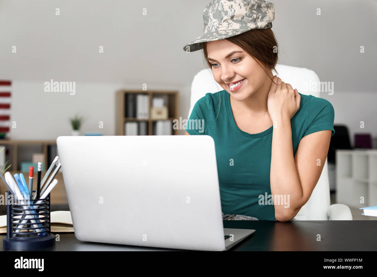 Young female soldier working with laptop in headquarters building Stock ...