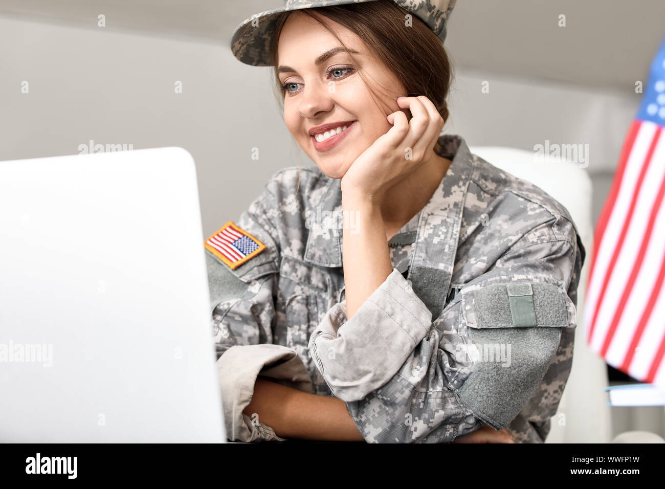 Young female soldier working with laptop in headquarters building Stock ...
