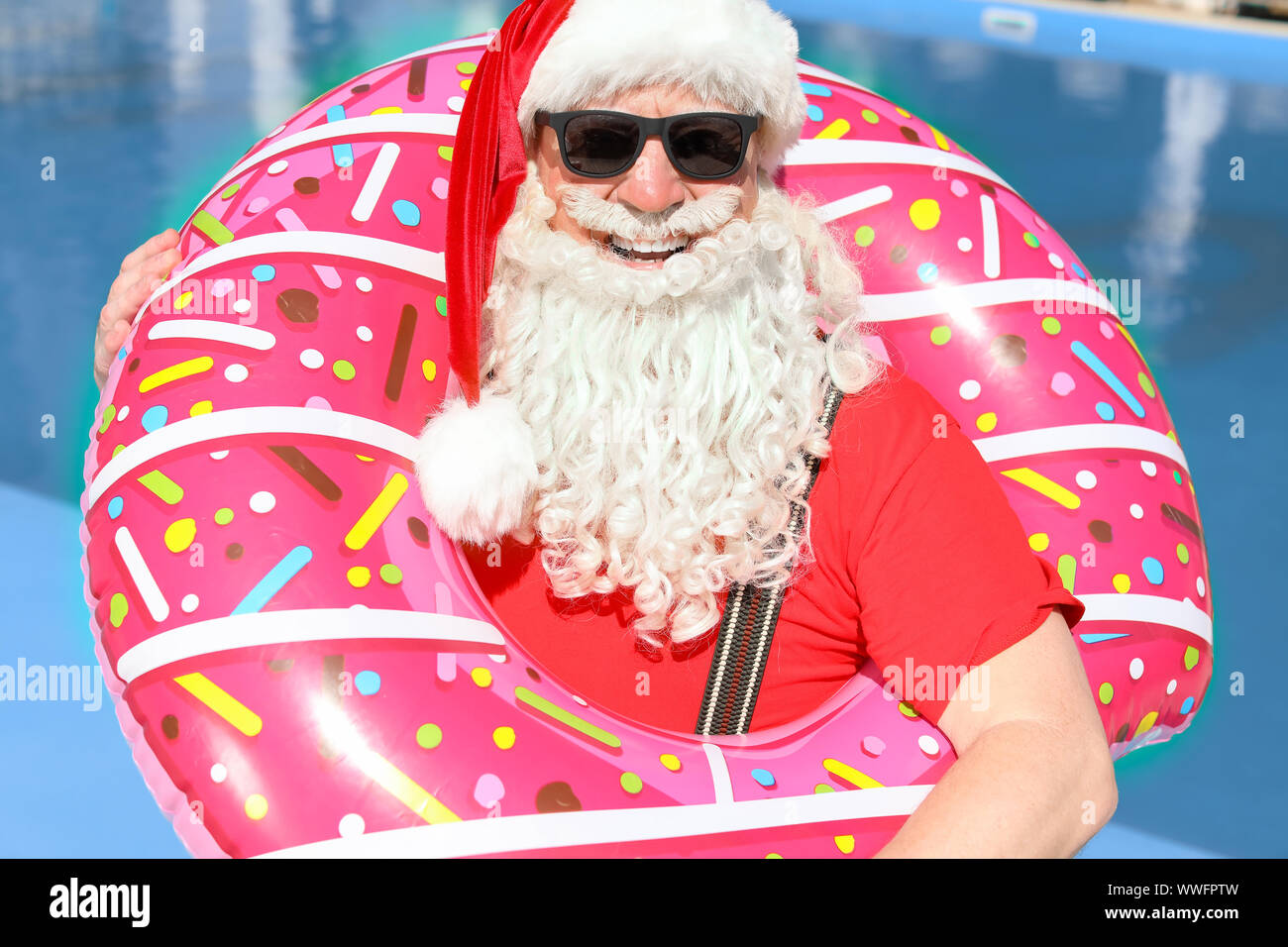 Santa Claus with inflatable ring near swimming pool at resort Stock