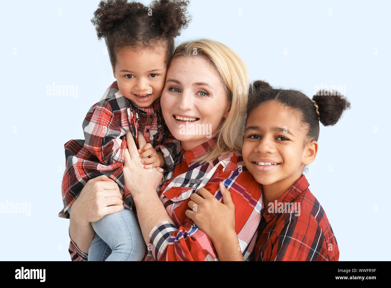 Happy woman with her African-American daughters on color background ...