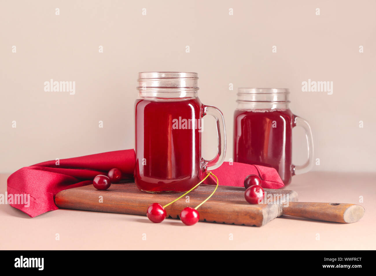 Mason jars of tasty cherry juice on light table Stock Photo - Alamy