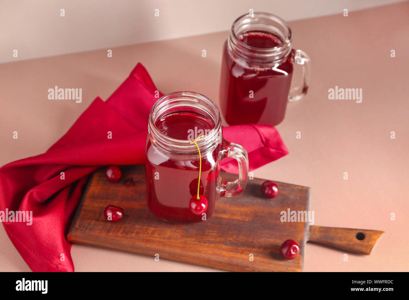 Mason jars of tasty cherry juice on light table Stock Photo - Alamy