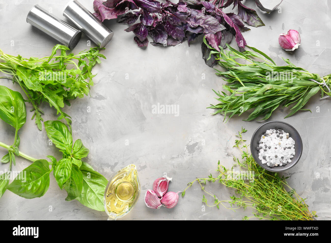Frame made of different fresh herbs with oil, salt and garlic on grunge ...