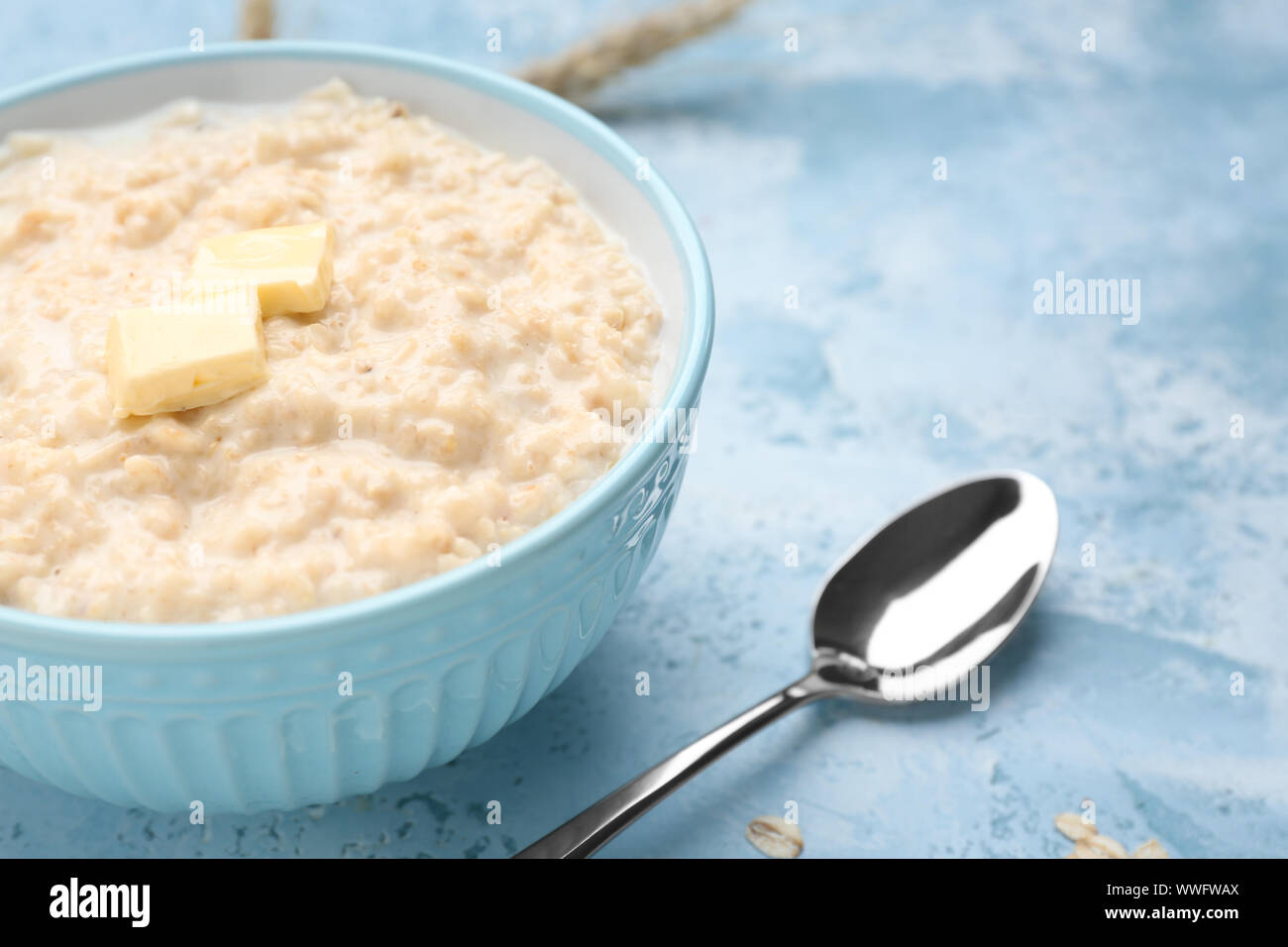 Bowl with tasty oatmeal on color background Stock Photo - Alamy