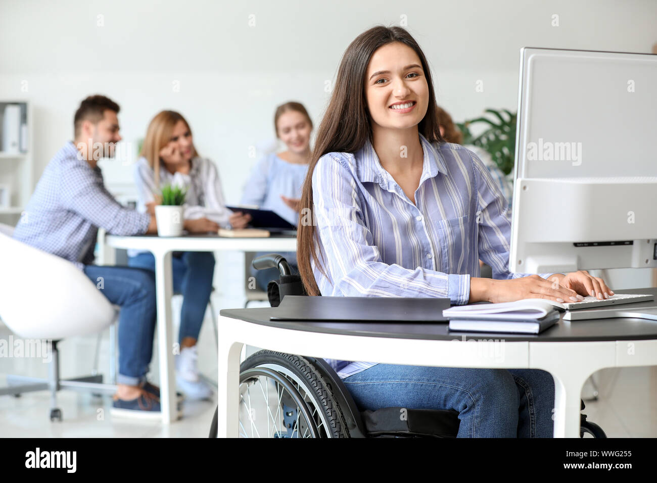 Handicapped young woman working in office Stock Photo - Alamy