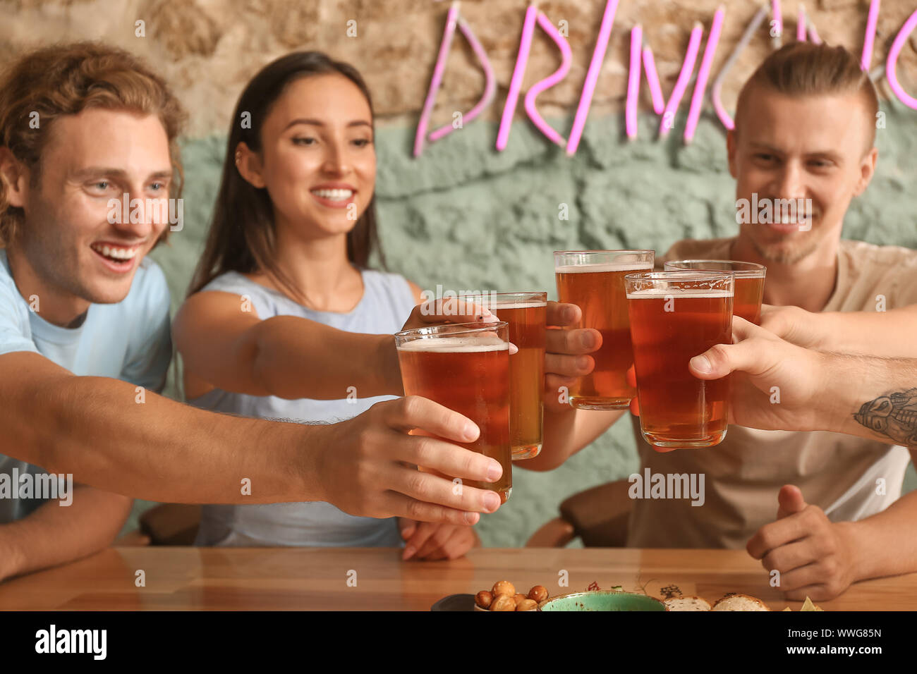 Friends drinking fresh beer in pub Stock Photo