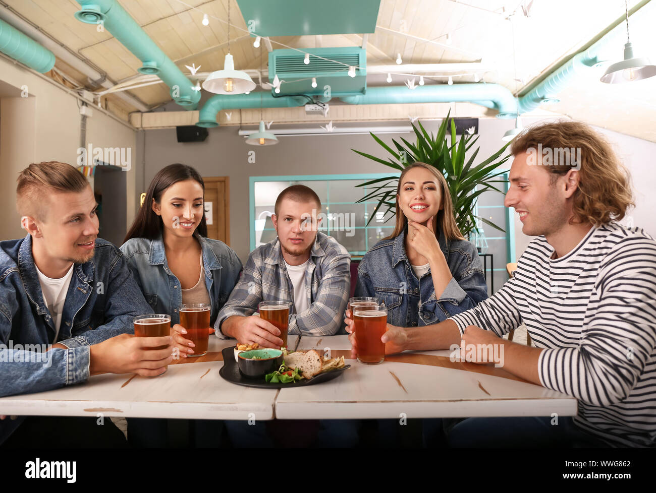 Friends drinking fresh beer in pub Stock Photo