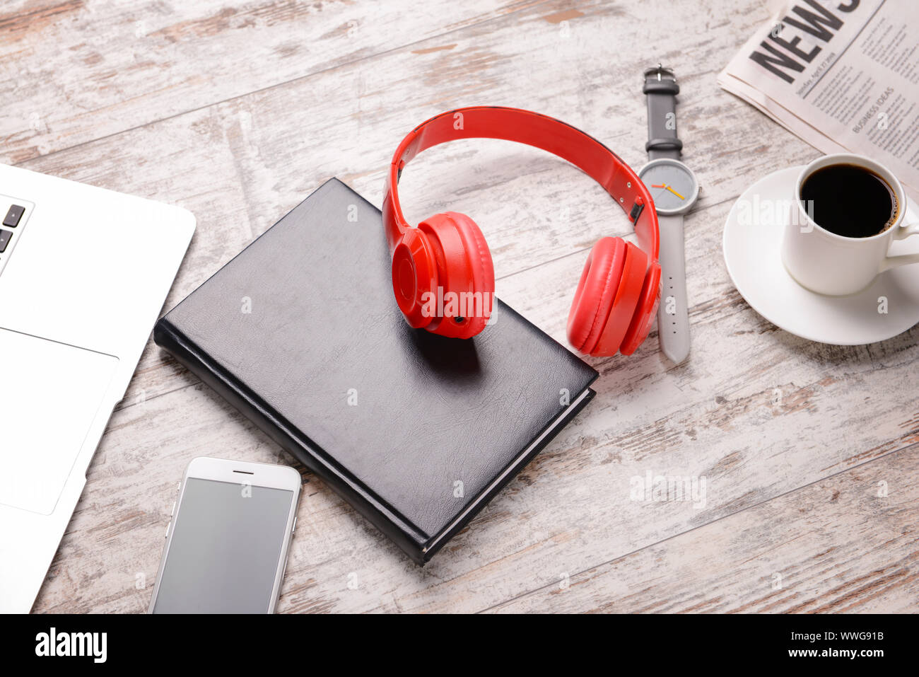 Modern headphones, notebook, laptop, cup of coffee and newspaper on ...