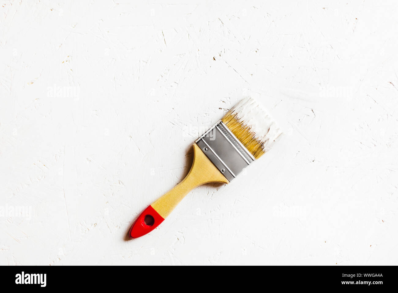 Covered in white paint construction brush. White painted plywood