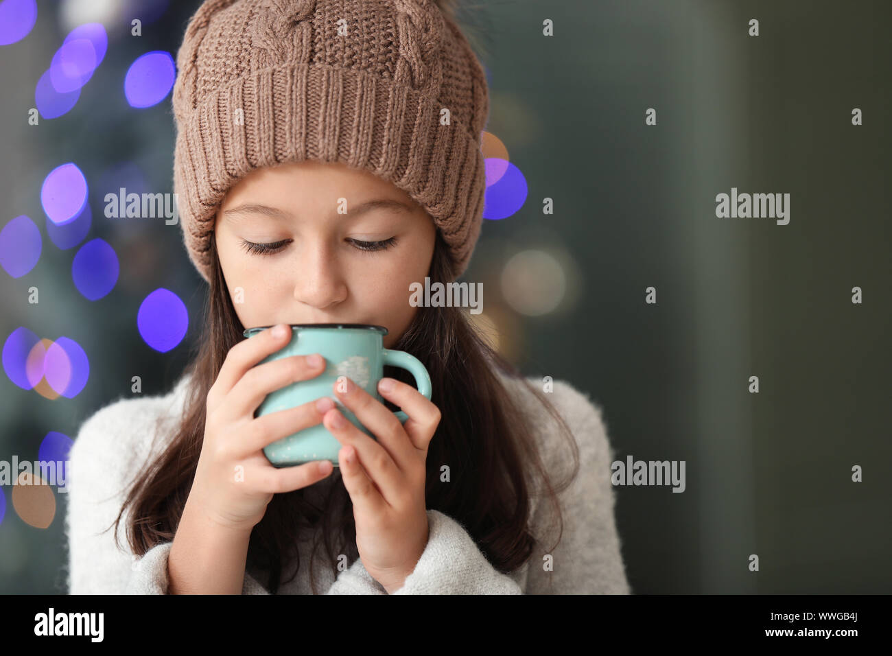 Little girl drinking hot chocolate at home on Christmas eve Stock Photo