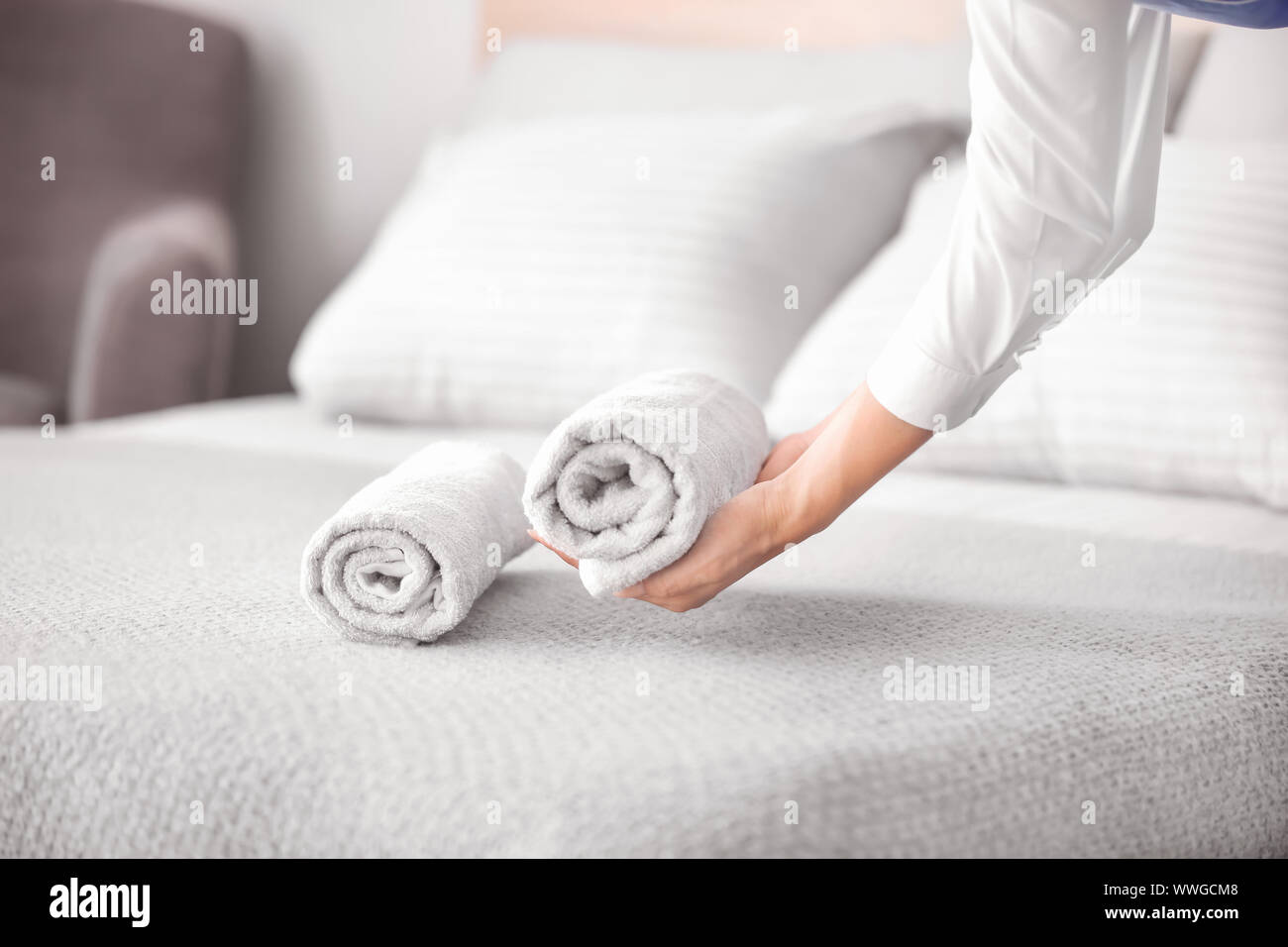 Female housekeeper putting clean towel on bed Stock Photo Alamy