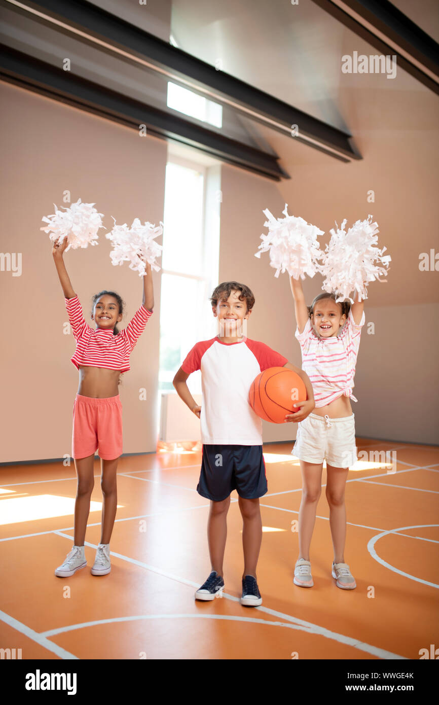Girls practicing cheerleading standing near classmate Stock Photo Alamy