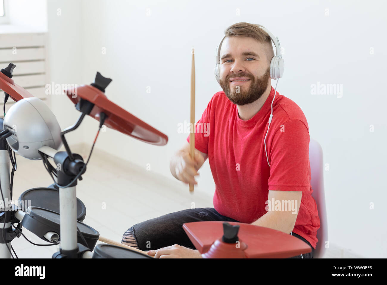 Music, people and hobby concept - man drummer playing the drum and looks like very emotional Stock Photo