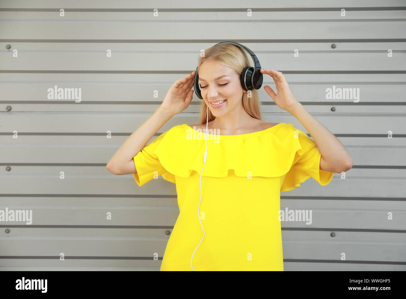 Beautiful young woman listening to music outdoors Stock Photo - Alamy