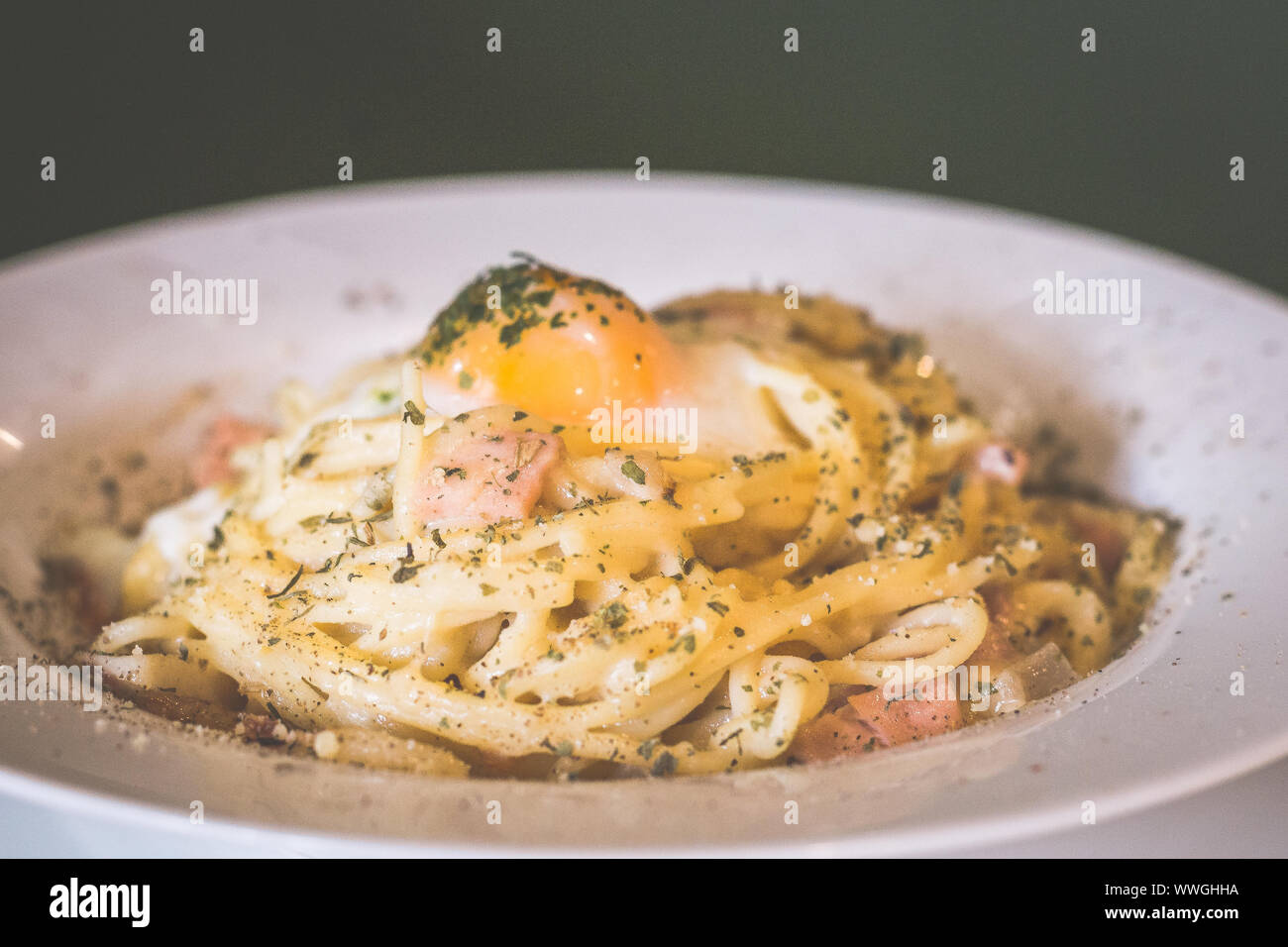 cheeszy duck spaghetti pasta in white carbonara sauce topped with sous vide egg and Stock - Alamy