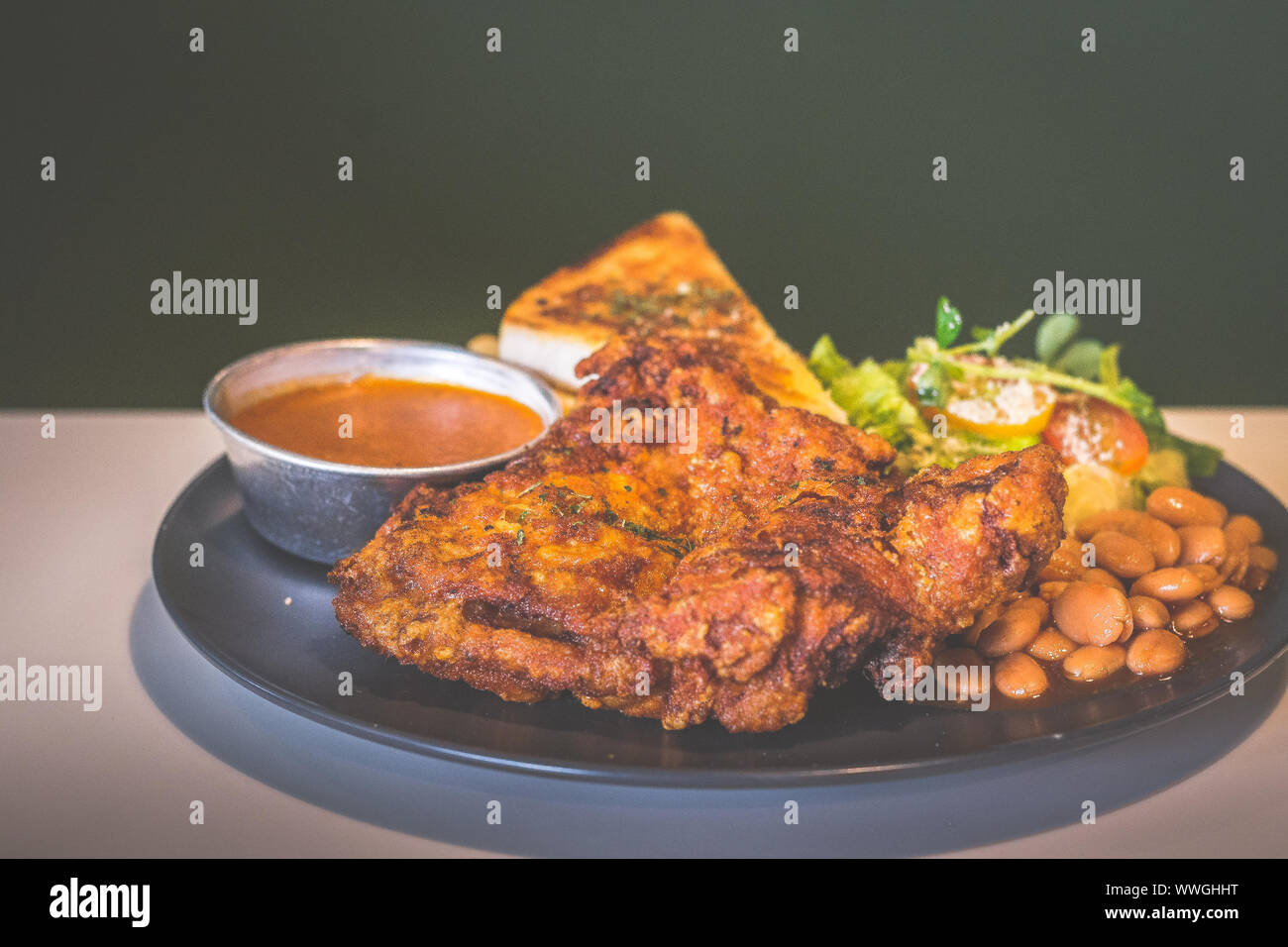 Deep fried chicken fillet with toast, sauce, baked beans, french fries and salad Stock Photo Alamy