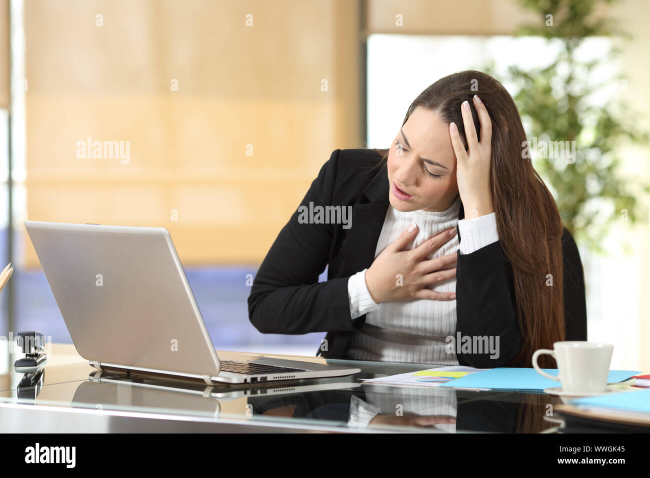 Businesswoman with stressful work suffering an anxiety attack at office Stock Photo