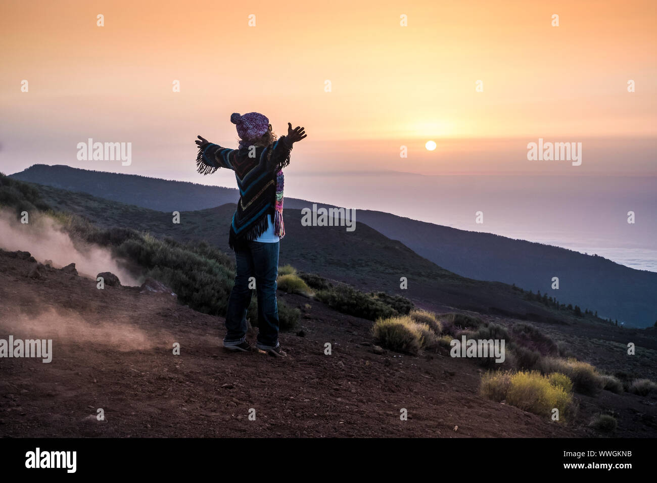 people enjoying open nature at the mountain during sunset -active woman in outdoor leisure activity with open arms - freedom and alternative lifestyle Stock Photo