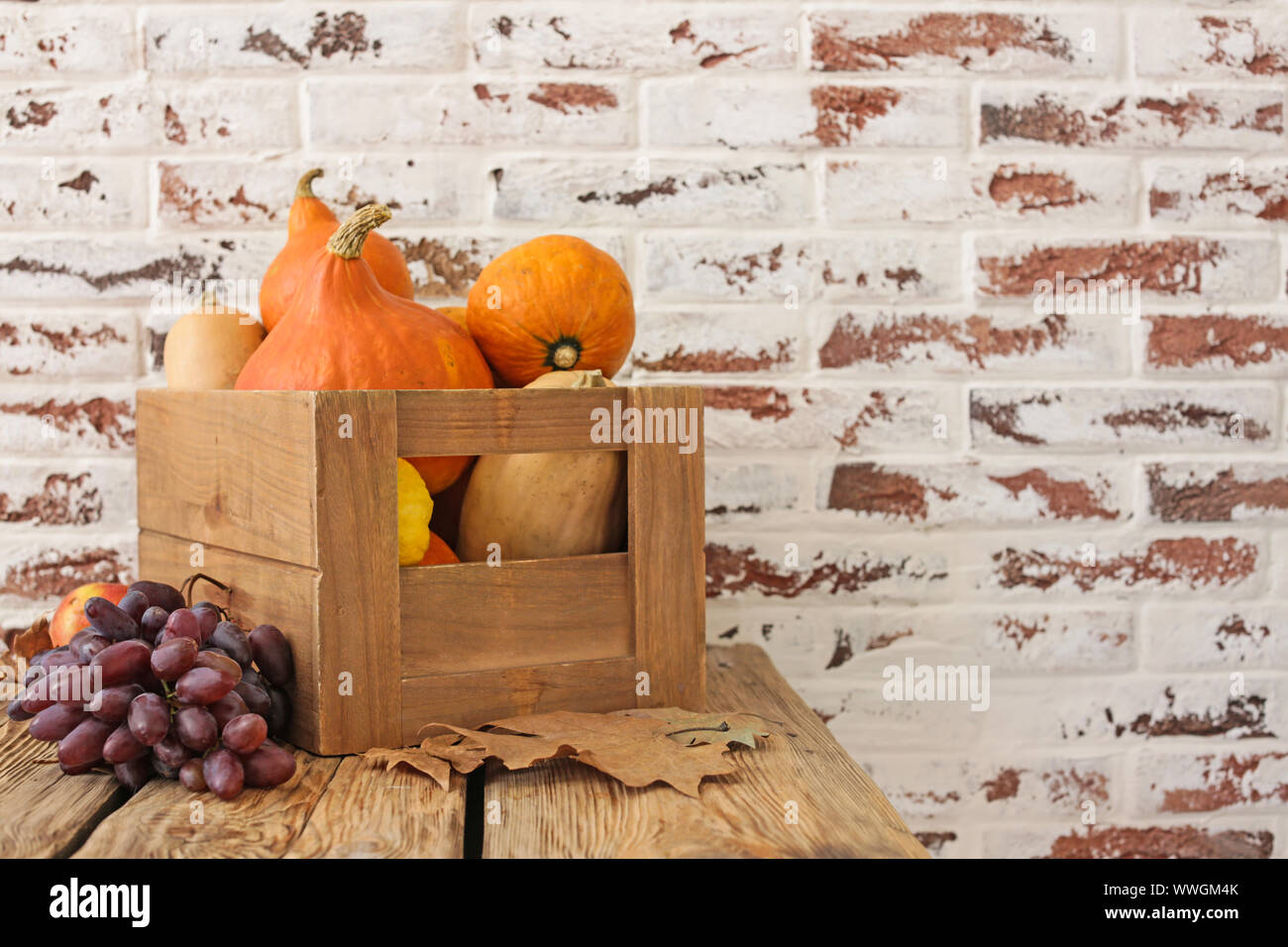 Wooden box with fresh pumpkins, squashes and fruits on table Stock ...