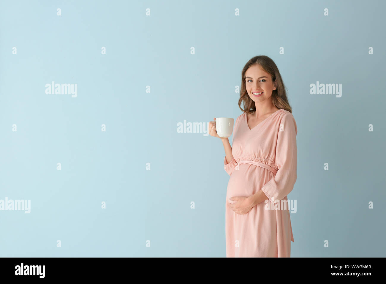Beautiful pregnant woman with cup of tea on color background Stock ...