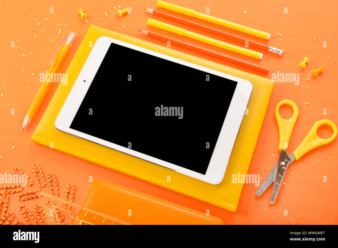 Modern tablet computer and stationery on color background Stock Photo