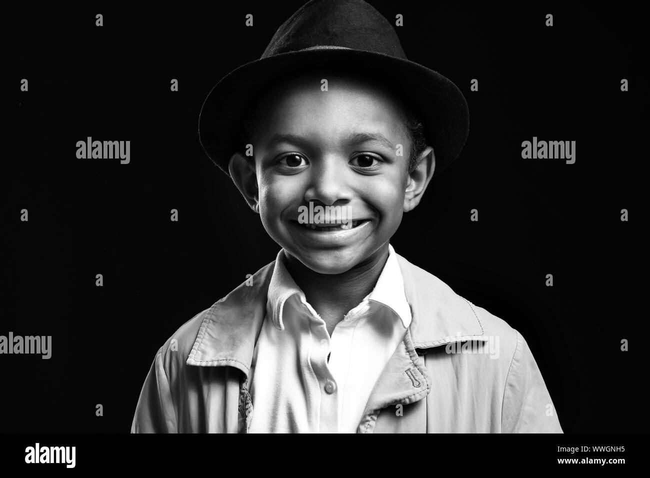 Black and white portrait of cute AfricanAmerican boy on dark